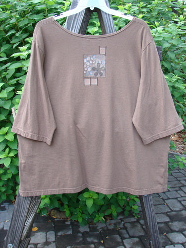 A brown Barclay Short Sleeved Tee with a square design on a clothes rack. Size 3. Chemistry Study theme paint.