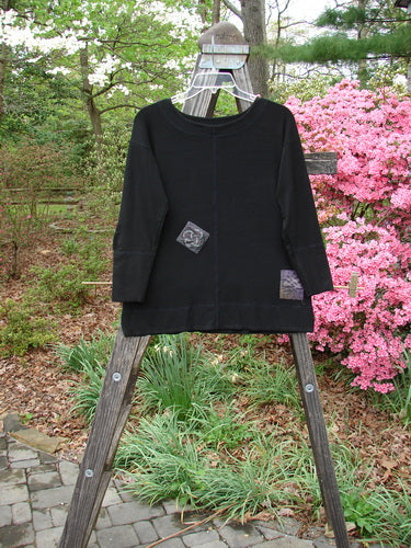 2000 Patched Rayon Lycra Rib Long Top Black Size 0 displayed on a wooden rack, showcasing its superior exterior paneled stitching, double-layered neckline, cuffs, and hemline.