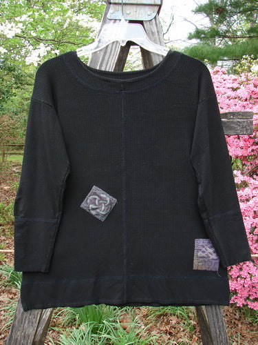 2000 Patched Rayon Lycra Rib Long Top Black Size 0 hanging on a clothes rack, showcasing paneled stitching, double-layered neckline, cuffs, hemline, and unique painted patches.