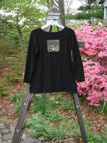 2000 Patched Rayon Lycra Rib Long Top Black Size 0, displayed on a wooden stand, featuring superior exterior paneled stitching and double-layered neckline, cuffs, and hemline, from Bluefishfinder's Holiday Collection.