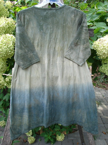 Barclay NWT Wander Tunic Tee Sunflower Mottled Vintage Camo Size 0, featuring a loose, oversized design with a tie-dye pattern transitioning from mossy green to soft blue, hanging outdoors.