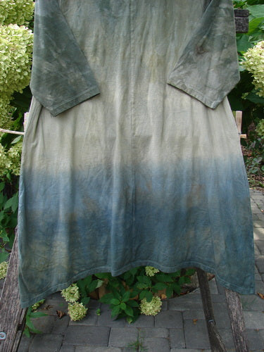 Barclay NWT Wander Tunic Tee Sunflower Mottled Vintage Camo Size 0 draped over a wooden chair, showcasing its gradient dye from olive-green to steely blue, three-quarter sleeves, and sunflower theme.