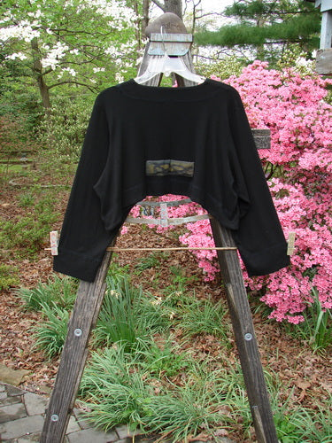 2000 Patched Rayon Lycra Rib Overtop Black Size 0 displayed on a wooden ladder, showcasing its textured fabric and dramatic hemline.