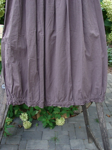 Barclay NWT Batiste Airy Lawn Skirt Unpainted Brown Sparrow Size 0, showcasing a loose fit with an elastic waist and gathered hem, draped over a wooden ladder amidst foliage.