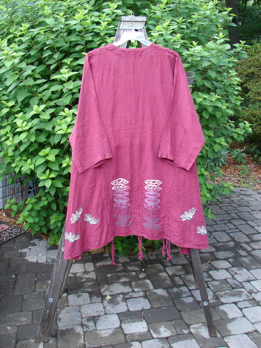 Barclay Linen Venetian High Vent Tunic Dress Cornflower Berry Size 2: A pink robe with a pattern on it, hanging on a rack.