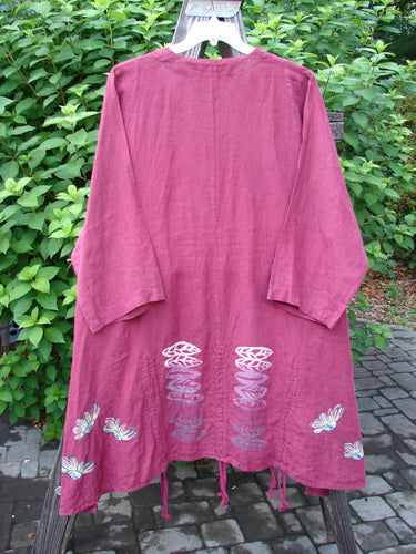 Barclay Linen Venetian High Vent Tunic Dress Cornflower Berry Size 2: A pink robe with a butterfly design, featuring a feminine hourglass shape, wider hip and hemline, and softly rolled neckline.