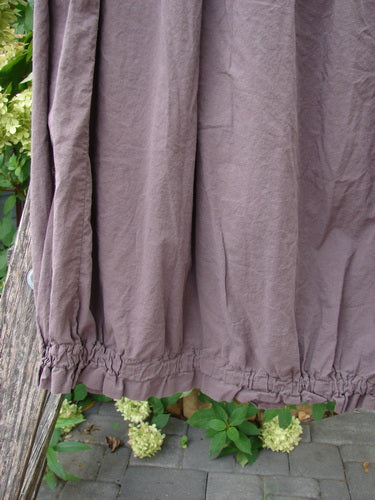Barclay NWT Batiste Airy Lawn Skirt Unpainted Brown Sparrow Size 0, featuring a loose fit with an elasticized hem, hangs against a rustic wooden background, capturing the skirt's unique shape and texture.