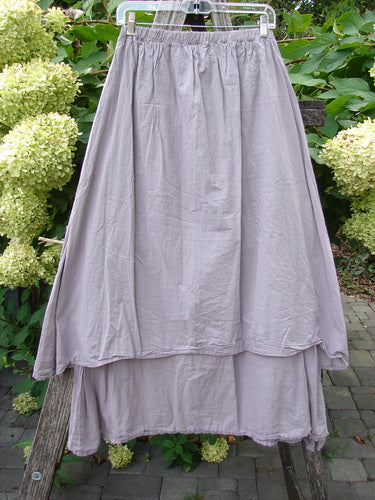 Barclay NWT Batiste Two Story Shaunting Skirt in Soft Mauve, features a two-tiered design with elastic waist, hangs outdoors, highlighting its flowing, lightweight cotton batiste fabric.