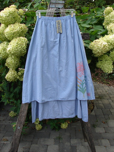 Barclay NWT Batiste Two Story Shaunting Skirt Side Floral Sky Size 0 on hanger, featuring a light-blue, two-layered design with a floral motif, displayed on a wooden ladder amidst garden setting.