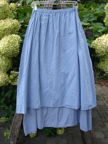 Barclay NWT Batiste Two Story Shaunting Skirt Side Floral Sky Size 0, featuring a sky-blue, dual-layer design with an elastic waistband, displayed outdoors, emphasizing its flowing silhouette and subtle pinstriped underskirt.