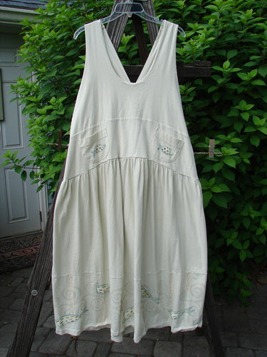 Image alt text: "1999 NWT Tadpole Jumper Double Dot Fish Natural OSFA: A white dress with pockets on a clothes rack, featuring adjustable shoulder straps, a sweeping hemline, a criss-cross lower back, a double-paneled waistline, a lower horizontal seam, and round bottomed pockets."