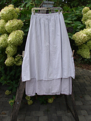 Barclay NWT Batiste Two Story Shaunting Skirt Unpainted Pearl Smoke Size 0, draped on a metal hanger over a ladder, showcasing its lightweight, double-layered cotton batiste with subtle pinstriped underskirt.