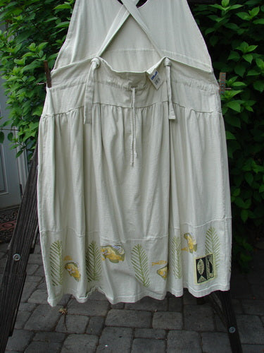 Image alt text: "1999 NWT Tadpole Jumper with gold fish theme, adjustable shoulder straps, sweeping hemline, and round bottomed pockets on a clothes line"