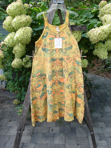 Magnolia Pearl NWT Cotton Fleece Lepidoptera Lana Tank Dress Butterfly Sunnies OSFA, featuring a vibrant butterfly pattern, hangs elegantly on a clear hanger against a natural, serene backdrop.