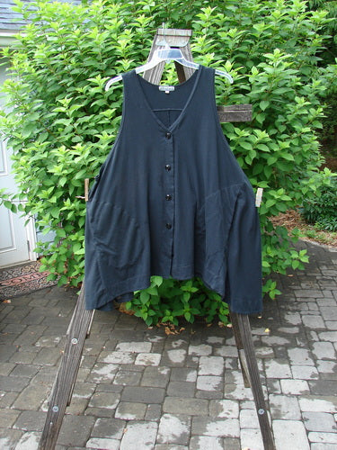 Barclay Column Vest Unpainted Midnight Size 2: A swingy shape vest with a downward yoked upper back shoulder panel, banded sway hemline, and dark contrasting buttons. Side seam deep pockets.