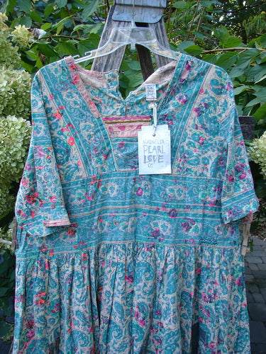 Magnolia Pearl NWT European Cotton Block Print Taigi Dress Demi OSFA features a bohemian design with floral paisley patterns, elbow-length sleeves, a gathered skirt, and square yoke bodice, hanging in a garden setting.