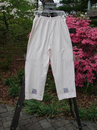 1996 Simple Pant Sea Life Birch Bark Size 1 displayed on a wooden rack, showcasing its cropped inseam, full elastic waistline, and side pockets. Made from organic cotton, part of the Summer Collection.