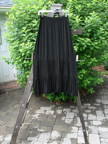 2000 Rayon Lycra Bubble Skirt Unpainted Black Size 1: A black skirt with a super gathered bubble bottom and tapered elastic hemline, hanging on a clothes rack.