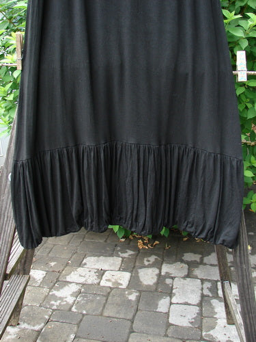 2000 Rayon Lycra Bubble Skirt Unpainted Black Size 1: A black skirt on a clothesline, featuring a super gathered bubble bottom and a tapered elastic hemline.