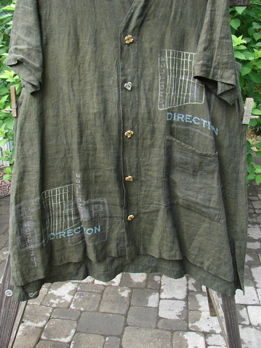2000 Cross Dye Linen Downtown Jacket Directional Oregano Size 2: A green shirt on a clothes line with ceramic glazed buttons.