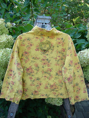 Magnolia Pearl NWT Cotton Fleece Asher Pullover Sweatshirt Vintage Rose Sunnies OSFA draped on a ladder, showcasing its cropped cut, wide sleeves, heart embroidery, and vintage rose print, embodying creative freedom.