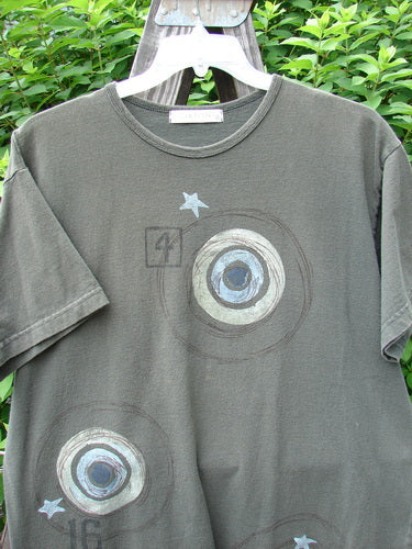 Image: A t-shirt with circles and stars on it.

Alt Text: 1998 Short Sleeved Tee Games Worn Domino Size 1: A t-shirt featuring circles and stars design from the Summer Collection of 1998.