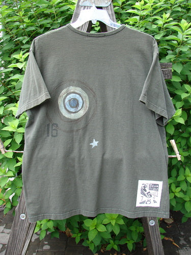 1998 Short Sleeved Tee Games Worn Domino Size 1: A t-shirt on a swinger with a design on it, featuring a close-up of a logo and a close-up of a circle.
