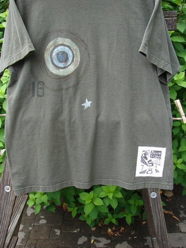 1998 Short Sleeved Tee Games Worn Domino Size 1: A t-shirt with a game theme paint design and a signature games patch. Medium fade and wear. Made from organic cotton. Bust 50, Waist 50, Hips 50, Length 30.