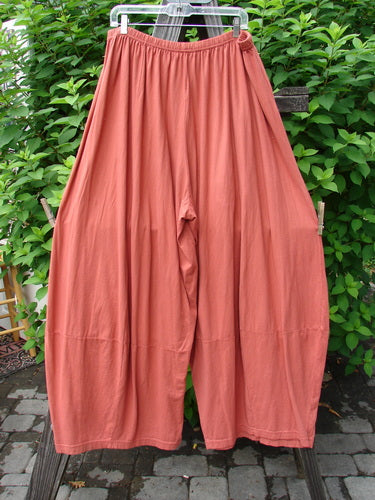 Barclay 4 Square Pant in Pumpkin, Size 2, made from Light Weight Organic Cotton. Unique bottom cut creates a 3D diamond shape from the knee down. Drape and movement add interest. Pocketless sway. Waist: 32-42, Hips: 72, Inseam: 27, Length: 45.