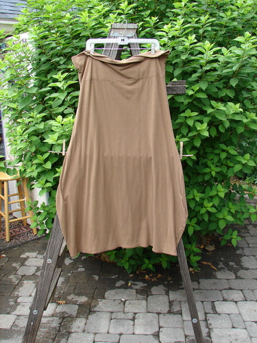 Barclay Cotton Lycra Fold Over Bottom Bell Skirt in Coco, size 2. A dress on a rack, showcasing a cross over front banded waistline, lower bell accent, and piped lower hem.