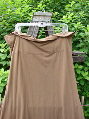 Barclay Cotton Lycra Fold Over Bottom Bell Skirt in Coco, Size 2. A skirt on a clothes rack, featuring a cross over front banded waistline, lower bell accent, and pipped lower hem. Made from organic cotton and lycra, this skirt offers a slimming flow.