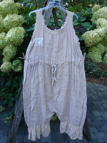 Magnolia Pearl Heavy Gauze Embroidered Signature Farm Love Overall Natural OSFA, featuring a drawstring waist, roomy harem-style legs with ruffled cuffs, and a chest patch pocket, hanging outdoors on a hanger.