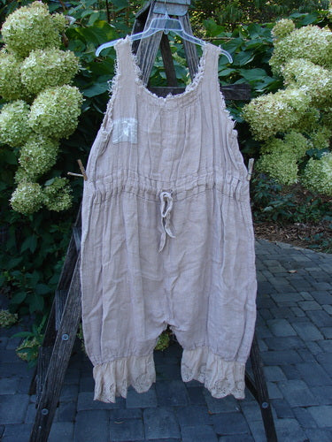 Magnolia Pearl Heavy Gauze Embroidered Signature Farm Love Overall Natural OSFA with ruffled leg cuffs and drawstring waist, hanging outdoors, showcasing unique raglan edgings and embroidered patch, reflecting Bluefishfinder.com's vintage style.