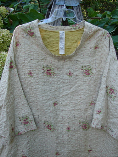 Magnolia Pearl European Cotton Quilted Hi Low Frances Top in Vintage Rose, featuring a crinkled texture with pink rose clusters, scoop neckline, high-low hem, drop dolman sleeves, and visible care label.