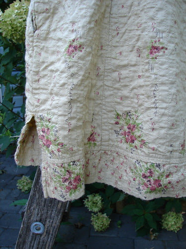 Magnolia Pearl European Cotton Quilted Hi Low Frances Top Vintage Rose OSFA displayed on a wooden garden ladder, featuring a floral pattern on creamy fabric, and showcasing its distinct high-low hem and billowy sleeves.