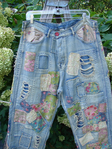 Magnolia Pearl NWT Denim Heavily Patched Miner Jean in Garden Patch features vibrant floral patches, distressed details, and adjustable waist and fly, showcasing a unique, artistic style.