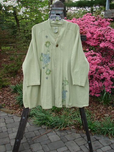 1996 Reprocessed Spring Rain Jacket Coral Reef Seedling OSFA displayed on a rack, featuring detailed floral patterns, deep side pockets, and a vintage closure.