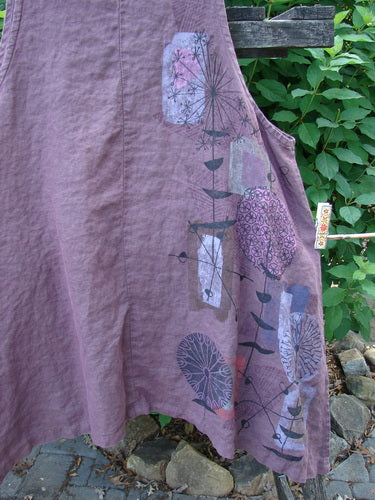 Barclay Linen Two Pocket Shirttail Pinafore Starburst Plum Wine Size 1 features a rounded neckline, A-line flair, double drop exterior pockets, and a single-sided starburst pattern, embodying vintage Blue Fish Clothing's creative essence.