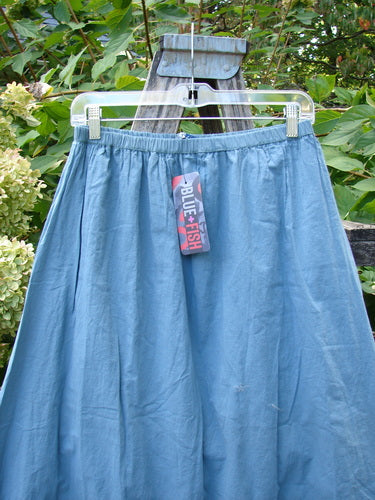 Barclay NWT Batiste Layer Skirt Unpainted Green Sea Size 0, full-length light-blue skirt with a two-story layered design, hangs on a clear hanger, displaying its wide hem sweep and tag.