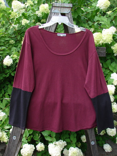 A red and black Barclay Contrast Bell Sleeve Top in Burgundy, made from Organic Cotton. Features include a slightly thinner and widening neck line, a very generous rounded shape lower shape, and contrasting lower long sleeves. This top has a slightly crop rounded length and a deeper rounded neckline. Bust 50, Waist 50, Hips 52, Length 26 Inches. Size 2.