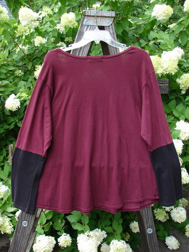 A red and black Barclay Contrast Bell Sleeve Top in Burgundy, made from Organic Cotton. Features include a thinner and widening neckline, contrasting lower long sleeves, and a slightly crop rounded length. Size 2.