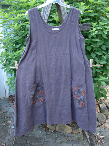 Barclay Linen Pocket Pinafore Polka Dot Plum Oversized Size 0, hanging on a clothesline, showcases an A-line flair with sectional panels and double drop polka dot pockets, embodying Blue Fish's vintage style.