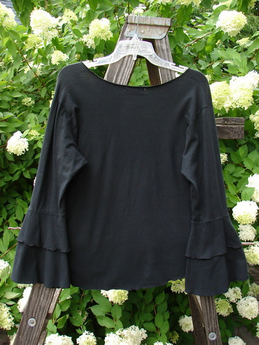 Barclay Cotton Lycra Long Sleeved Petal Top Unpainted Black Size 0: A black shirt with a rounded raw neckline, fluttered lowers, and exterior curly stitchery.