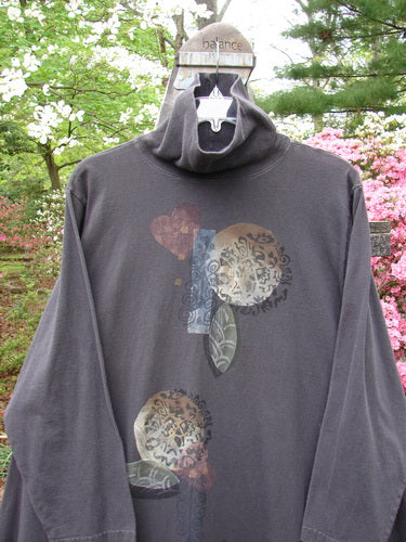 A vintage 1995 Omega Dress from Bloomsberry in perfect condition. Features a generous turtleneck, drop shoulders, deep pockets, A-line flare, and Moon Flower theme. Blue Fish signature patch. Person wearing grey sweatshirt on a swing.
