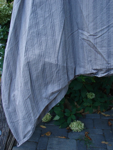 Barclay NWT Percale Hado Shift Stripe Moon Rock Sand Size 1 displayed outdoors, showcasing lightweight pin-striped cotton with a deeper scoop neckline and varying hem against foliage and a wooden fence backdrop.