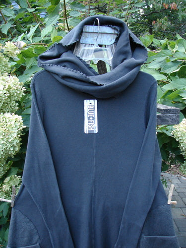 Barclay NWT Thermal Cloud Forest Pocket Tunic Unpainted Smoke Size 0, featuring a unique draped cowl-hood, long sleeves, and cozy Celtic Moss circle pockets, displayed on a hanger outdoors.