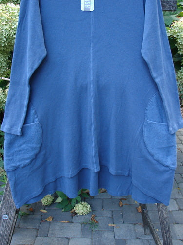 Barclay NWT Thermal Cloud Forest Pocket Tunic Top Unpainted Vintage Indigo Size 1 displayed on a wooden bench, showcasing long sleeves, patch pockets, A-line flare, and an upward scooped hemline.