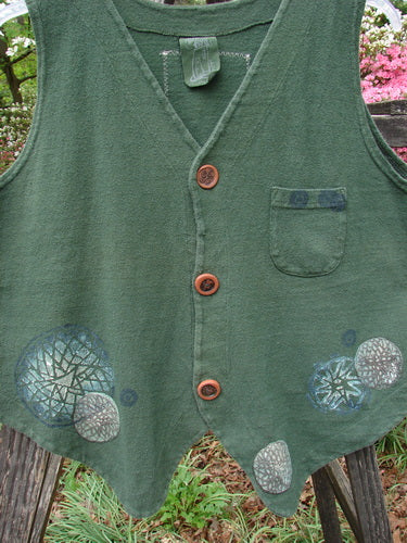 Vintage 1995 Reprocessed Drawing Room Vest in Star Spin Green Tea. Features ceramic buttons, tailored drawcord back, front pocket, and Blue Fish signature patch. Crafted from thick cotton in deep forest green.