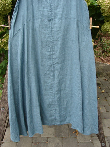 Barclay NWT Linen Tulip Midlayer Overpiece Unpainted La Mer Size 0, elegantly hung on a clothesline, showcasing its layered crossover front, sweeping A-line flare, and slightly scooped neckline.