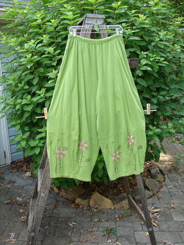 Barclay 4 Square Pant Floral Reach Spearmint Size 0, features a unique 3D diamond drape from the knee down with floral patterns, full elastic waistband, and pockets, displayed on a clothesline.